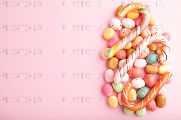 Various caramel candies on pink pastel background. copy space, top view, flat lay