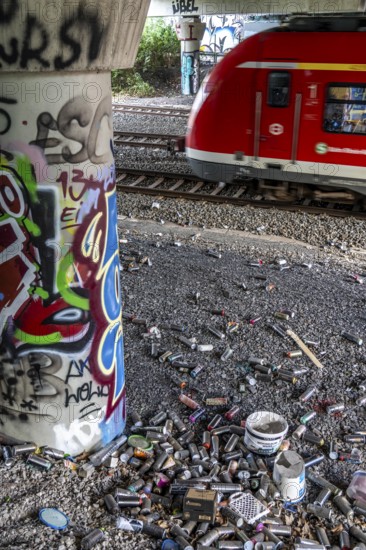 Empty spray paint cans, on a railway line below a road bridge, thrown away, disposed of by the sprayer, graffiti, rubbish heap, Essen, North Rhine-Westphalia, Germany, Europe