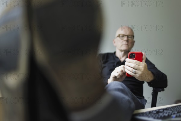 Topic: Man with smartphone in the office, Bonn, 04.07.2024