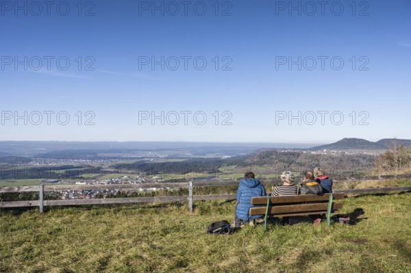 Hikers resting on a bench at the viewpoint from the 980 metre high Klippeneck on the western edge of the Swabian Alb, Denkingen, Tuttlingen district, Baden-Württemberg, Germany, Europe