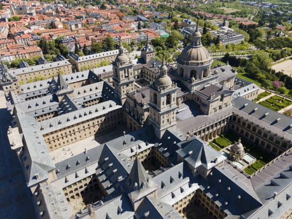 Aerial view of a historic monastery with towers and nearby town, surrounded by green landscape, Aerial view, Real Sitio de San Lorenzo de El Escorial, Royal Seat of St Lawrence of El Escorial, palace and monastery complex, San Lorenzo de El Escorial, Madrid, Spain, UNESCO World Heritage Site, Europe