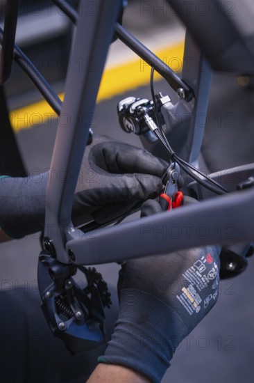 Gloved hands with pliers during bicycle assembly, Waldbike Manufaktur, bicycle workshop, Calw, district of Calw, Black Forest, Germany, Europe