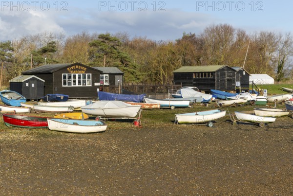 Fishing sheds and boats dinghies on trailers, Riverside tearoom, Orford, Suffolk, England, UK