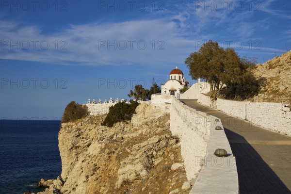 A church on a cliff overlooking the sea on a clear, sunny day, Agios Nikolaos church, cemetery, Pigadia, town and harbour, Pigadia Bay, main town, Karpathos, Dodecanese, Greek Islands, Greece, Europe