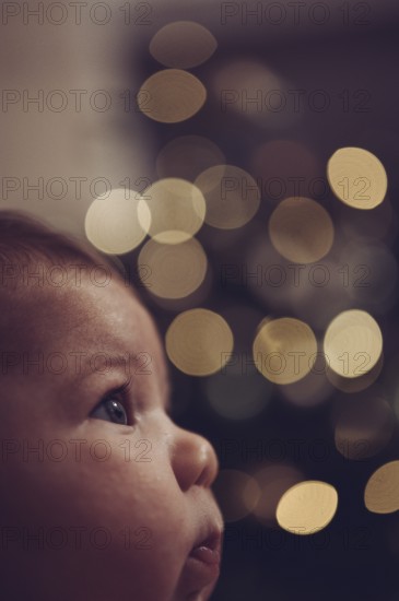 Close-up of a baby with blurred points of light in the background