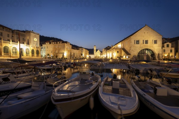 Town view of the harbour at night with boats and historic buildings, Hvar, Croatia, Europe