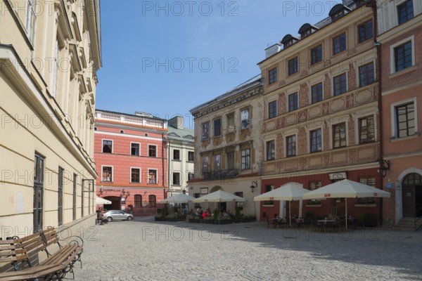 Cobbled old town alleyway with historic buildings and sunlight, benches at the roadside, Old Town Market Square, Lublin, Poland, Europe