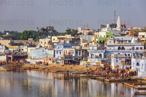 PUSHKAR, INDIA, NOVEMBER 20, 2012: Hindu devotees pilgrims bathing in sacred Puskhar lake (Sagar) on ghats of Pushkar, Rajasthan, India. Pushkar is holy city for Hinduists and famous for many Hindu temples