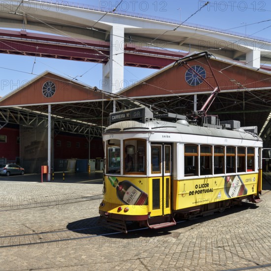 Historic yellow tram, Eléctrico, line 28 in front of tram depot and repair shop, Lisbon, Portugal, Europe