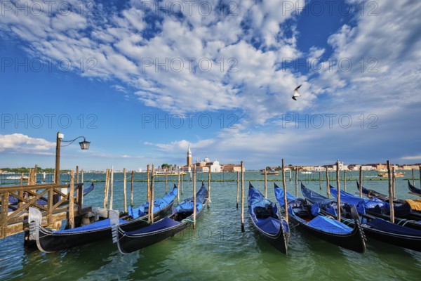 Gondolas and in lagoon of Venice by Saint Mark (San Marco) square with San Giorgio di Maggiore church in background in Venice, Italy, Europe