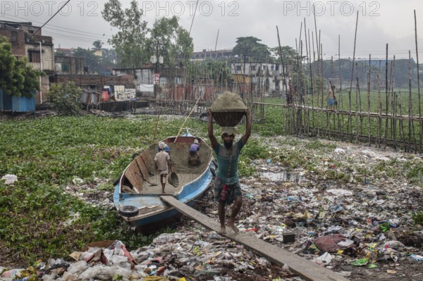 Construction workers transporting sand from a boat over a plank, Tel Ghat, Dhaka, Bangladesh, Asia