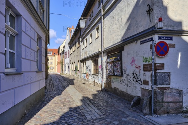 View through the hollow alley of Bechermacherstraße at the corner of Badenstraße, graffitied facade of the listed building Badenstraße 45, which once housed the Bären-Apotheke, UNESCO World Heritage Site, Hanseatic City of Stralsund, Mecklenburg, Western Pomerania