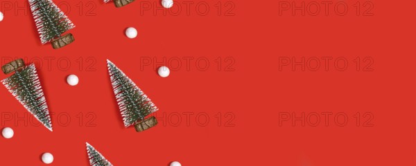 Red Christmas banner with trees and snowballs on red background with copy space