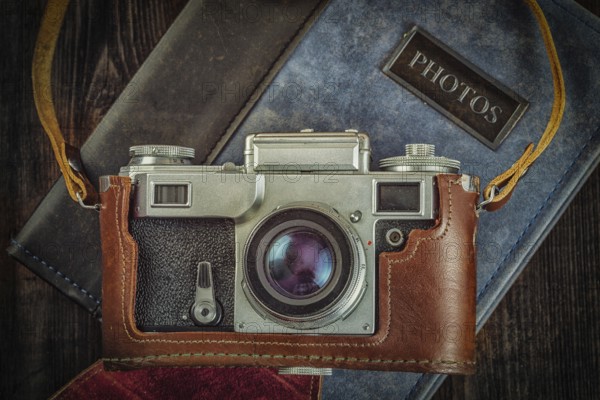 Photography concept background, old retro vintage camera on photo album on grunge wooden texture