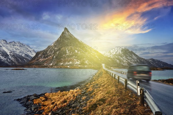 Car on road in Norwegian fjord on sunset. Lofoten islands, Norway. With motion blur