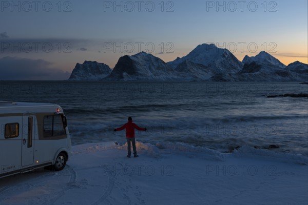 Motorhome in winter on pitch with view of fjord and snow-capped mountains, Storsandnes Beach, Myrland, Lofoten, Norway, Europe