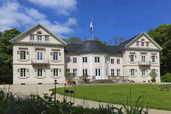 Villa Eugenia, last residence of the Princes of Hohenzollern-Hechingen, classicist central building built from 1786 to 1787 by Prince Joseph Wilhelm as a summer pleasure garden house, side wings added from 1833 to 1834, residence for the then hereditary prince and later princely couple Friedrich Wilhelm Konstantin and Eugenie, meadow, park, garden, historic building, architecture, clouds, sky, flagpole, Hohenzollern coat of arms, Hechingen, Zollernalbkreis, Baden-Württemberg, Germany, Europe