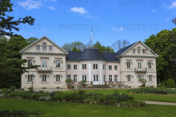 Villa Eugenia, last residence of the Princes of Hohenzollern-Hechingen, classicist central building built from 1786 to 1787 by Prince Joseph Wilhelm as a summer pleasure garden house, side wings added from 1833 to 1834, residence for the then hereditary prince and later princely couple Friedrich Wilhelm Konstantin and Eugenie, meadow, park, garden, historic building, architecture, clouds, sky, flagpole, Hohenzollern coat of arms, Hechingen, Zollernalbkreis, Baden-Württemberg, Germany, Europe