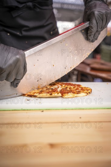 Pizza cutter with pizza, Calw, Black Forest, Germany, Europe