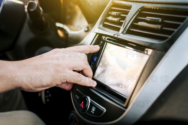 Driver hands changing the radio station. Close up of hands changing the car radio station. Concept of driver tuning the radio. Driver man changing radio station