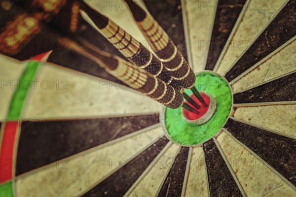 Vintage retro effect filtered hipster style image of, Success hitting target aim goal achievement concept background, three darts in bull's eye close up