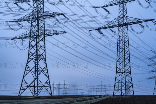 Large power line, 380 KV extra-high voltage lines, near Rommerskirchen, RWE lignite-fired power station Niederaußem in the fog, North Rhine-Westphalia, Germany, Europe