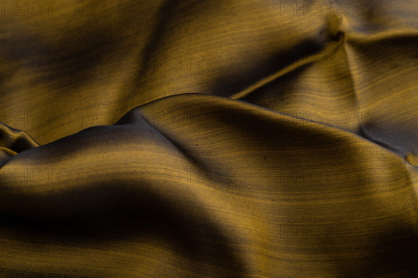 Fragment of yellow and green tissue. Side view, synthetic textile background and texture. wave concept, abstract