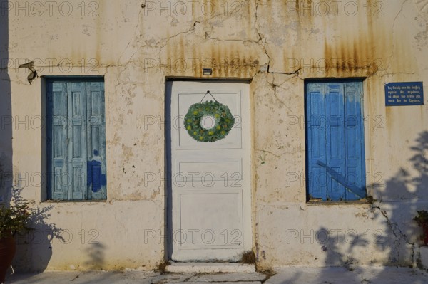 Detail of a house with blue shutters and decorated white door, Pyles village, west coast, Karpathos, Dodecanese, Greek Islands, Greece, Europe