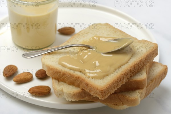 Almond cream on toast, almonds and spoon