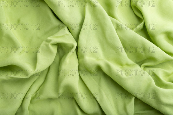 Fragment of green linen tissue. Top view, natural textile background and texture. wave concept, abstract