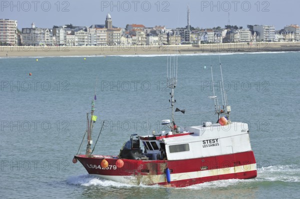 Fishing boat and apartments along the coastline at Les Sables-d'Olonne, La Vendée, Pays de la Loire, France, Europe