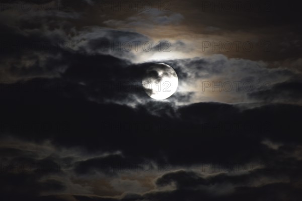 Full moon shines through the clouds