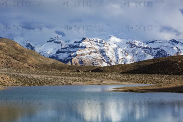 Himalayas mountains refelcting in mountain lake Dhankar Lake. Spiti Valley, Himachal Pradesh, India, Asia