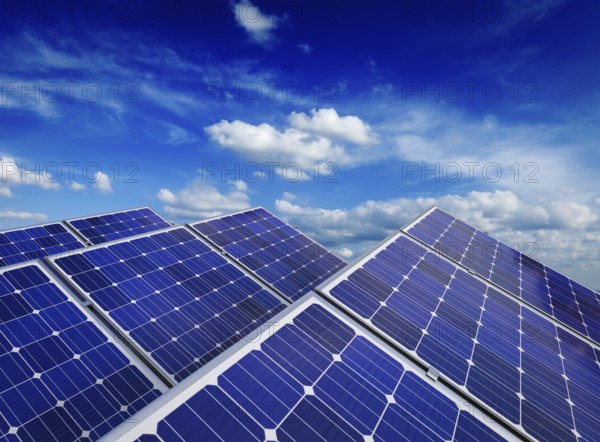 Solar power generation technology, alternative renewable energy and environment protection ecology concept, close up of solar battery panels against blue sky with clouds