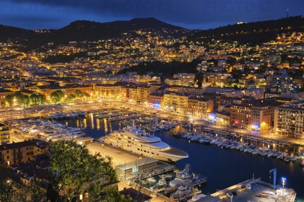 View of Old Port of Nice with luxury yacht boats from Castle Hill, France, Villefranche-sur-Mer, Nice, Cote d'Azur, French Riviera in the evening blue hour twilight illuminated, Europe