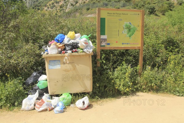 Overflowing rubbish bin at natural park, Cueva del Gato, Benaojan, Serrania de Ronda, Malaga province, Spain, Europe