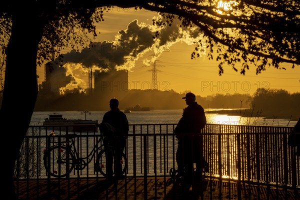 Rhine promenade in Duisburg-Wanheim, sunset, view of the Rhine and Hüttenwerke Krupp Mannesmann, coking plant, Duisburg, North Rhine-Westphalia, Germany, Europe