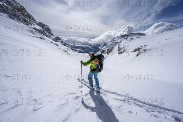 Ski tourers descending in fresh snow, Bernese Alps, Switzerland, Europe