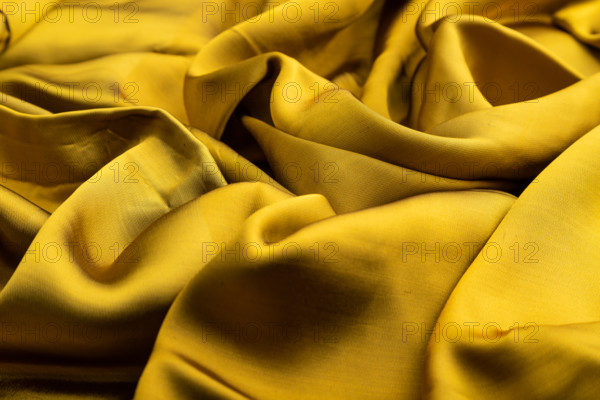 Fragment of yellow and green tissue. Side view, synthetic textile background and texture. wave concept, abstract