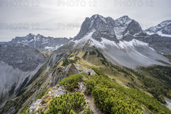 Mountaineers on a hiking trail on the ridge of Hahnkampl, mountain panorama with rocky steep peaks, view of summit Lamsenspitze, in autumn, Karwendel Mountains, Alpenpark Karwendel, Tyrol, Austria, Europe