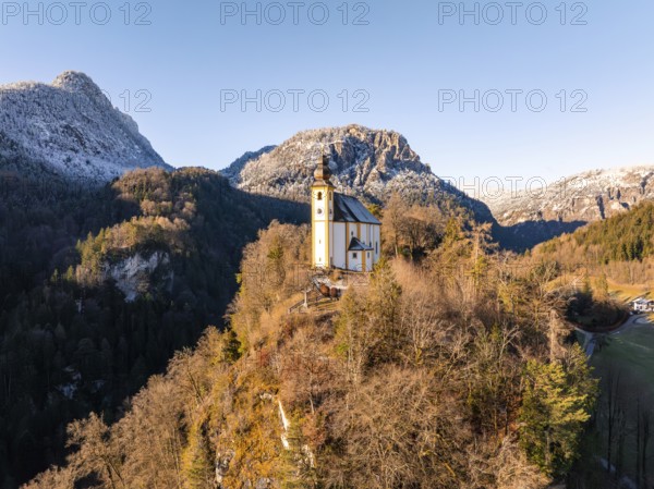 Church on a hill with snow-covered mountains in the background at sunrise, St Pankraz, Karlstein, Bad Reichenhall, Germany, Europe