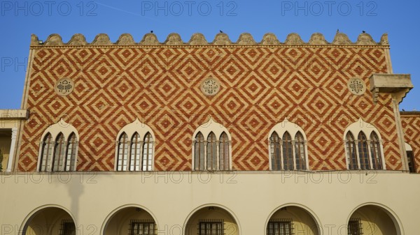 A historic building with a red and white pattern and battlements on the roof, harbour area, Rhodes Town, Rhodes, Dodecanese, Greek Islands, Greece, Europe