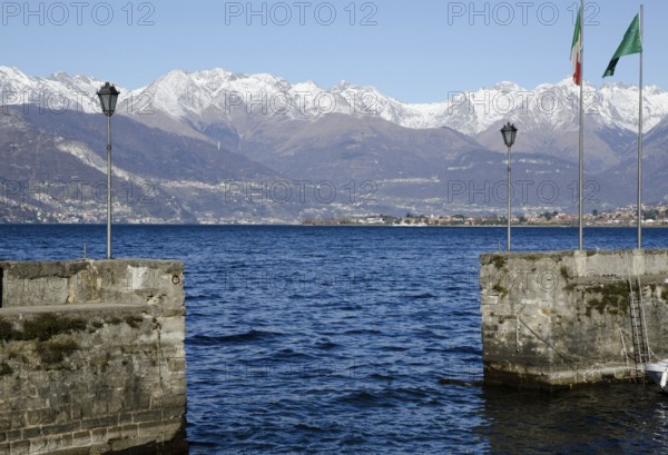 Harbour on an Alpine Lake Como with Snow Capped Mountain in a Sunny Day in Lombardy, Italy, Europe