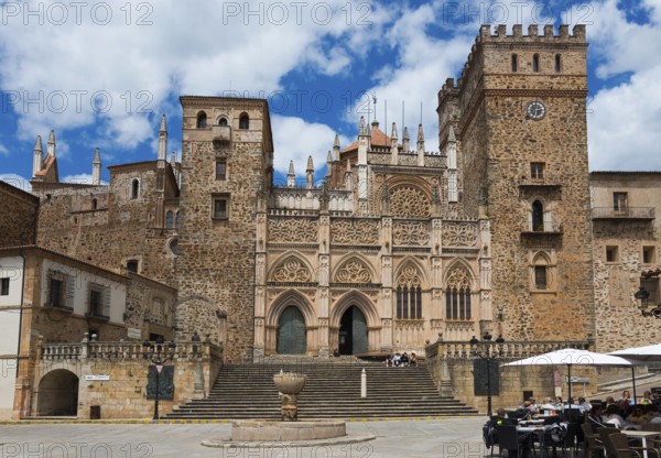 Historisches steinernes Gebäude auf einem Platz unter einem bewölkten Himmel, Wallfahrtskirche und Kloster, Real Monasterio de Nuestra Señora de Guadalupe, Guadalupe, Provinz Cáceres, Caceres, Extremadura, Spanien