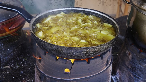 A pan of unpeeled potatoes roasting over an open fire, surrounded by steam, Slowfood Restaurant Dounias, Drakona, Lefka Ori, White Mountains, mountain massif, west, Crete, Greece, Europe