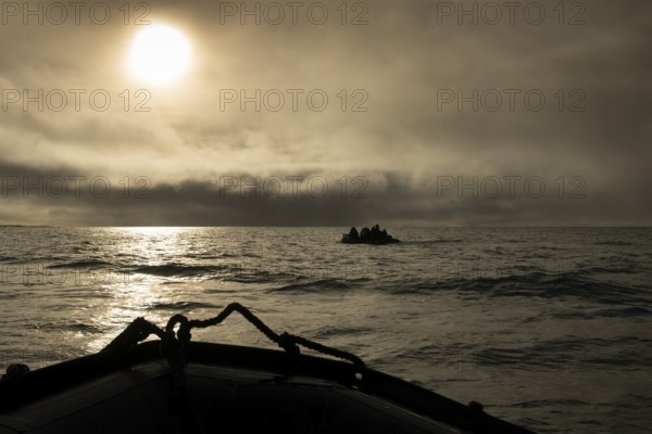 Inflatable boats, tourists, sun behind clouds, Kvitøya, Svalbard and Jan Mayen archipelago, Norway, Europe