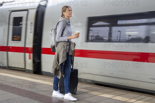 Young woman on the railway track while a train arrives