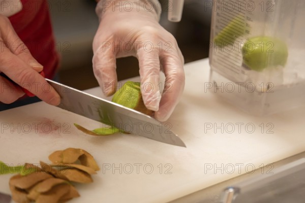 Wheat Ridge, Colorado, Joshua Hudson peels kiwi fruit to make a smoothie at his Twisted Smoothie Company