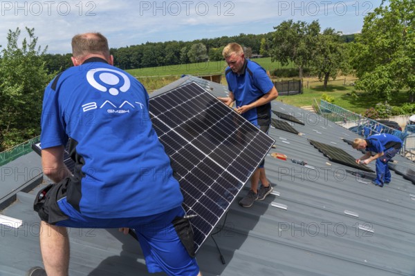 Installation of solar modules on the roof of a barn on a farm, over 240 photovoltaic modules are installed on the roof, North Rhine-Westphalia, Germany, Europe