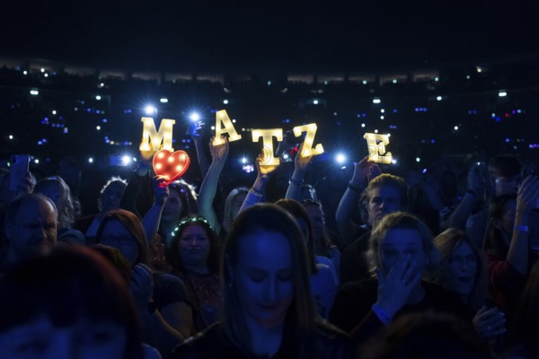 Fans hold up bright letters MATZE for Matthias Reim on the ..und plötzlich bist du Kult! Tour at the Uber Arena in Berlin on 29 December 2024